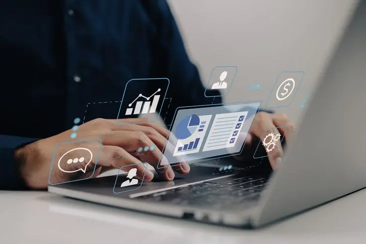 Laptop with floating digital analytics icons, symbolizing modern business solutions by a web designer in Thrissur, Kerala