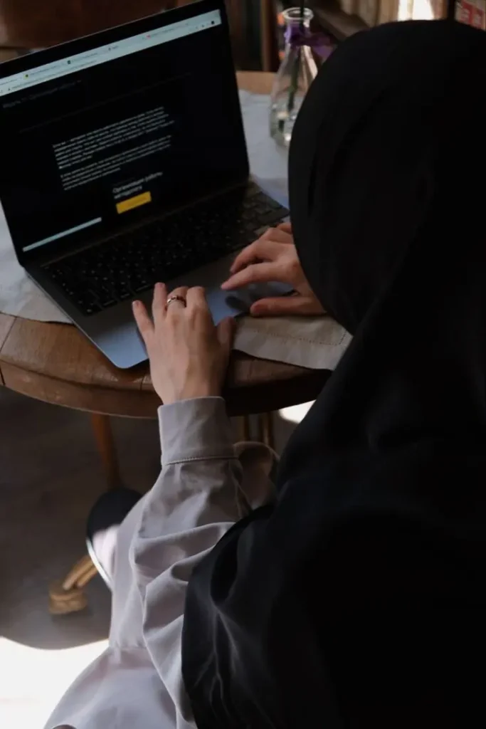 Freelance digital marketer working on laptop in café, focused on online strategy