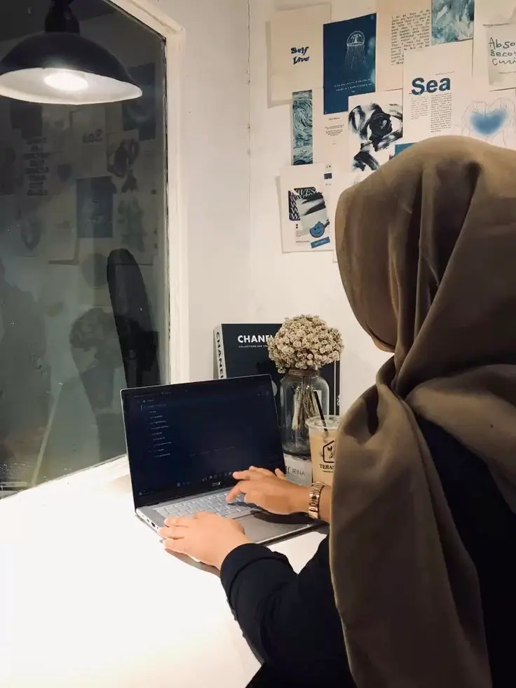 Female web designer in Thrissur, Kerala working on a laptop in a creative home office setup
